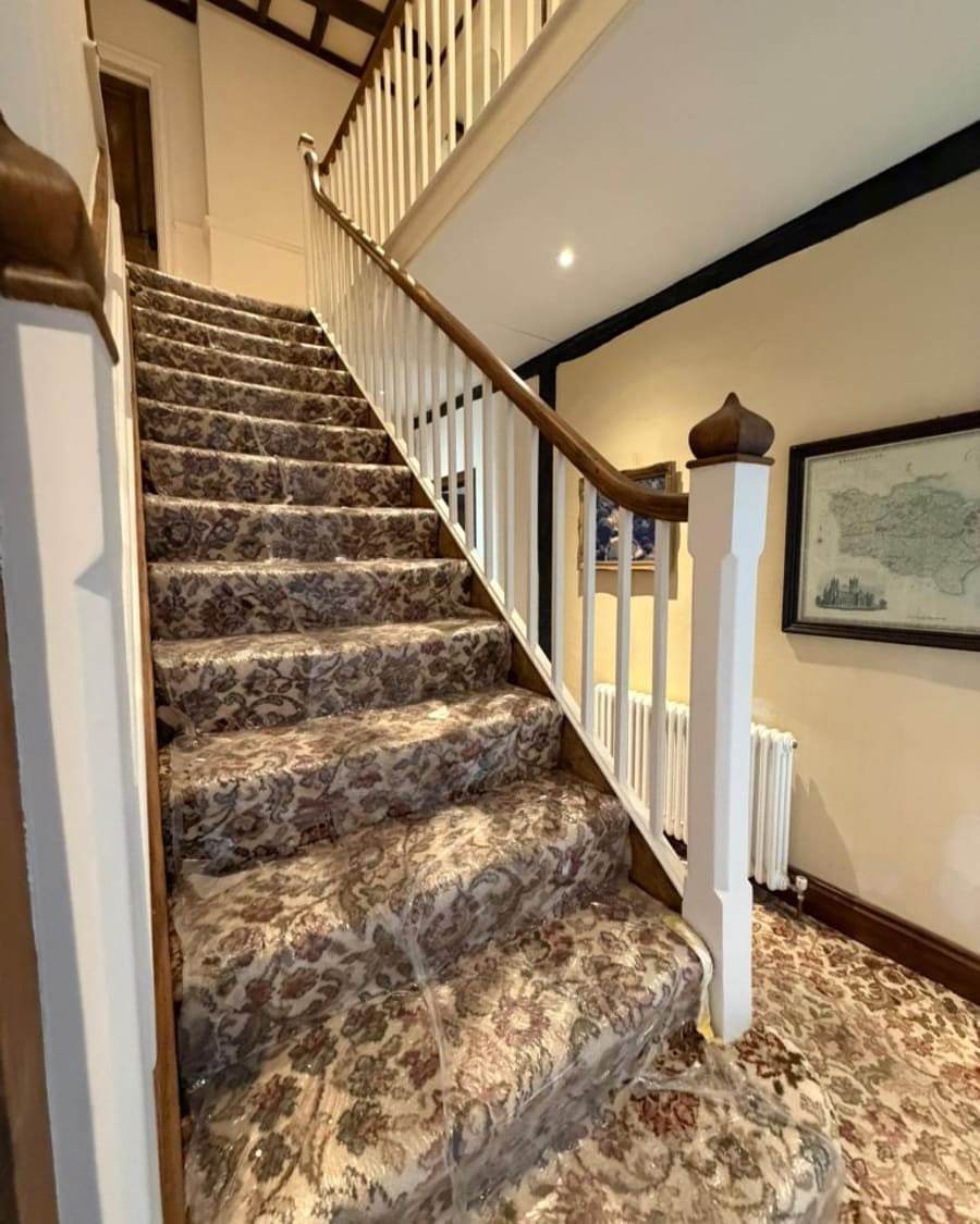 After — restored staircase with white spindles and polished handrail