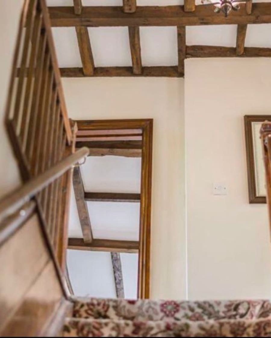 Before — dark wood banister and tired staircase carpet