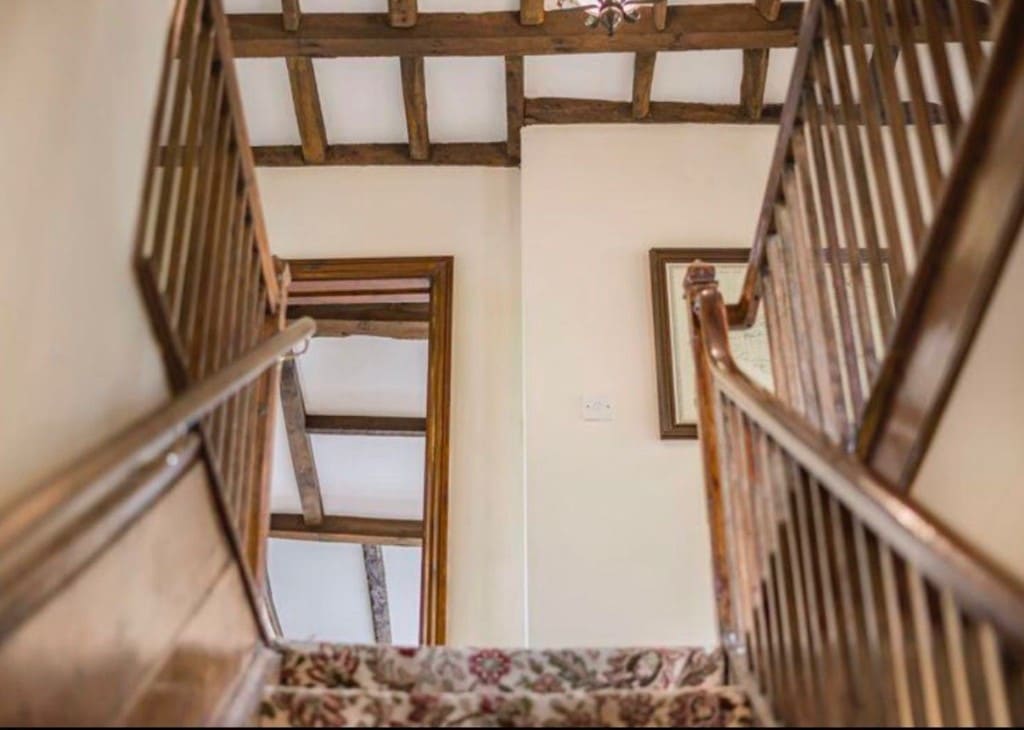 Before — dated staircase with dark wood banister and tired carpet