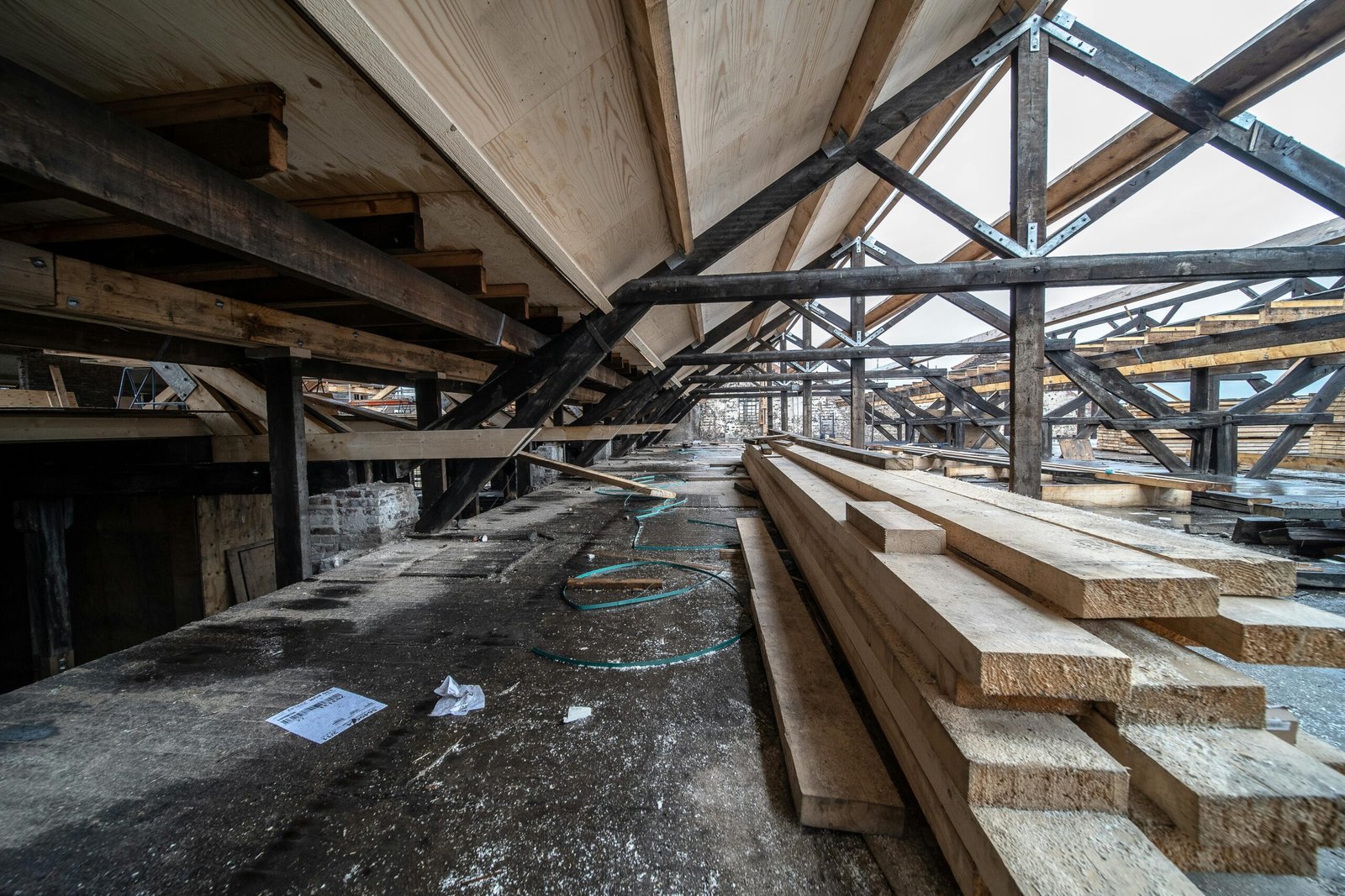 Detailed view of wooden beams in a loft under construction, showcasing structural design and materials.